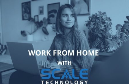 A woman is working from home securely, sitting at her laptop and smiling.