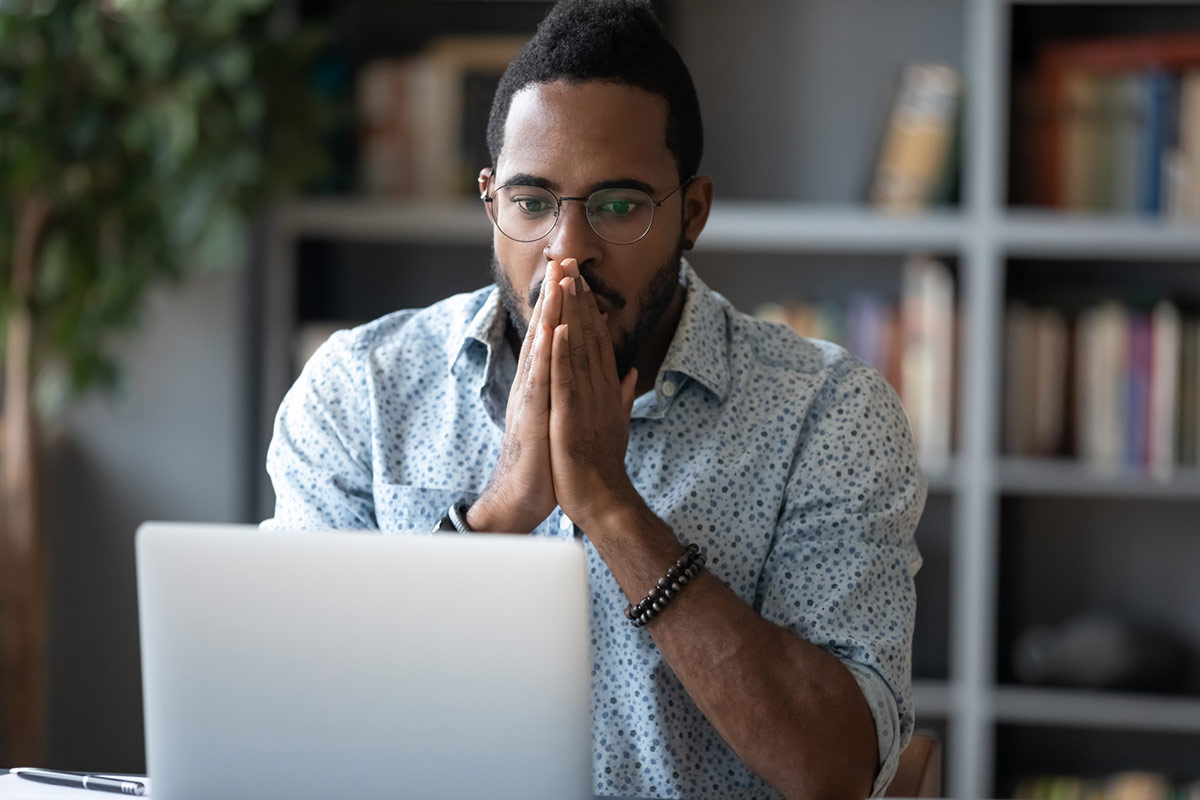 a man praying at his computer